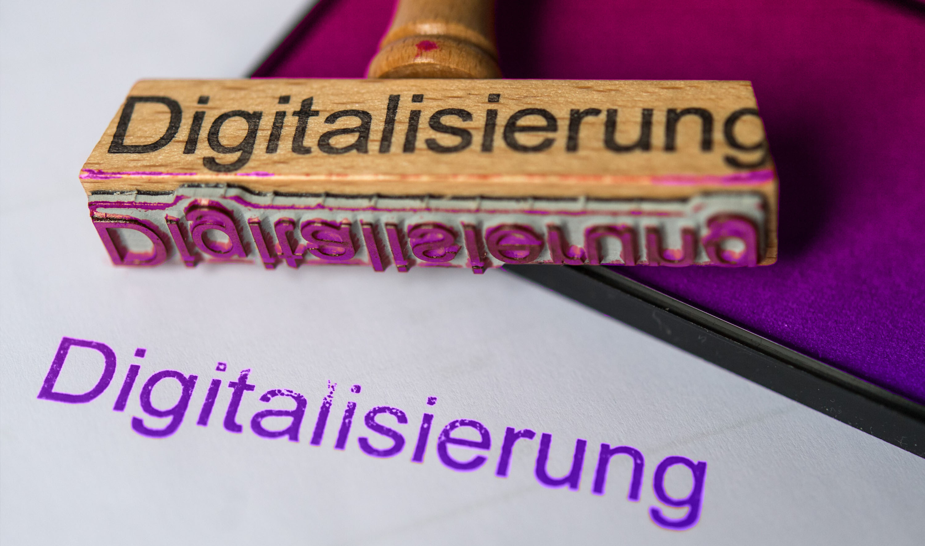 Das Wort "Digitalisierung" wird auf ein Papier gestempelt